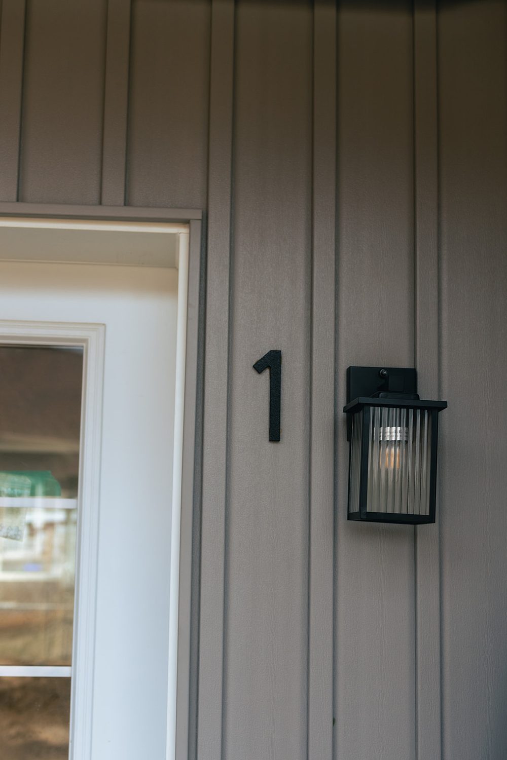 A unit entrance with its number and sconce